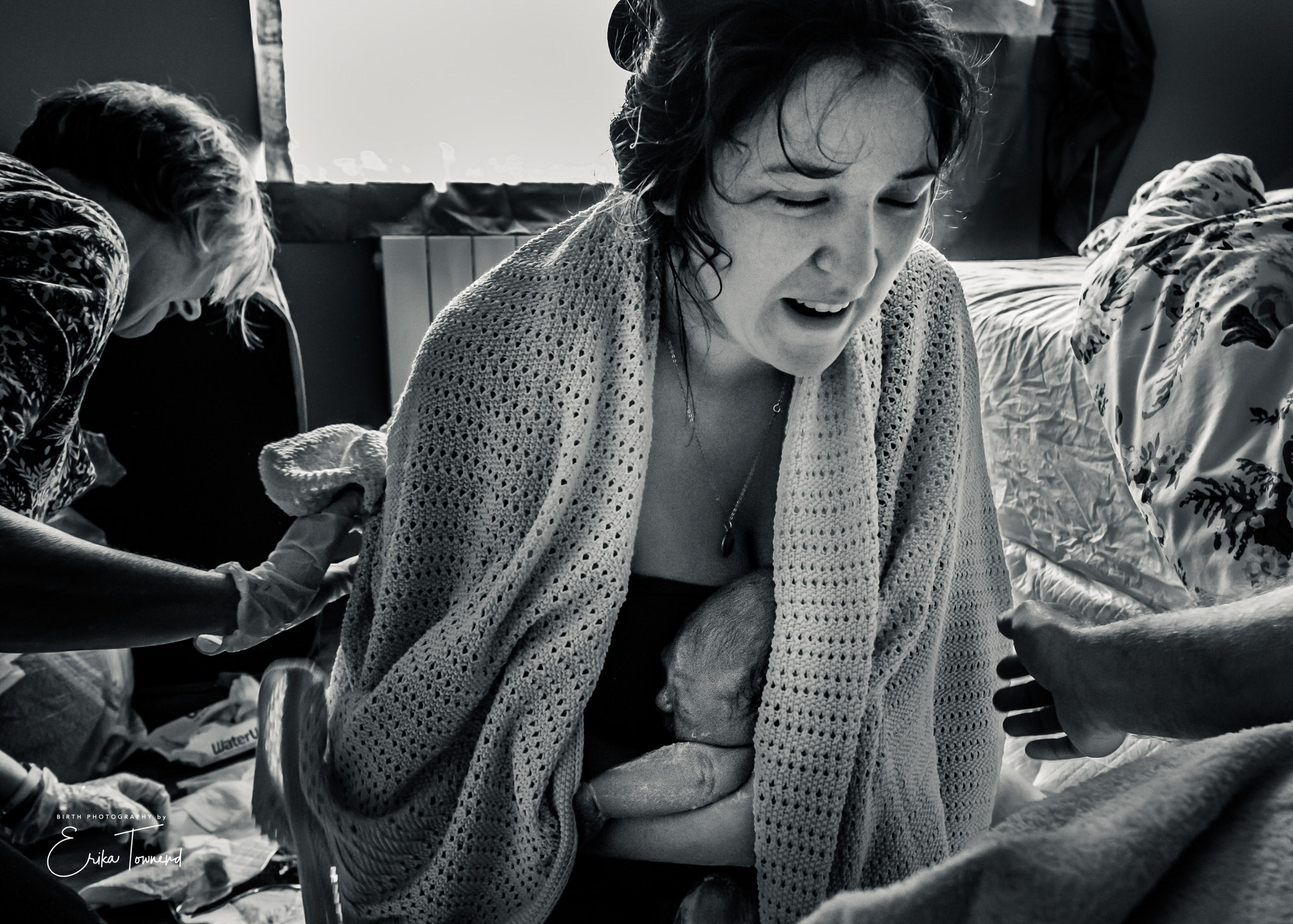 Black and white image of elation as woman meets her baby immediately after birth at home with a midwife Birth Photography in Berkshire and Surrey