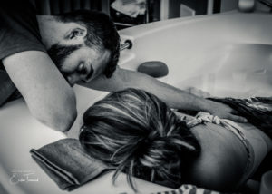 Black and white image of a couple using Hypnobirth skills whilst relaxing in the pool by Erika Townend Birth